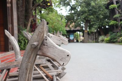 Close-up of wooden rocking horses on footpath