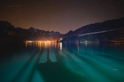 Scenic view of lake against sky at night