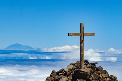 Cross on mountain against blue sky