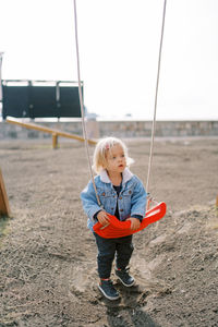 Portrait of boy swinging at playground