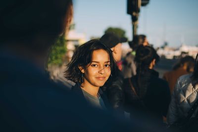 Portrait of smiling woman against sky