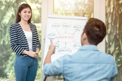 Smiling young woman standing against wall