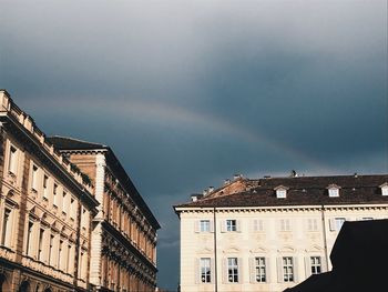 Low angle view of rainbow over buildings in city