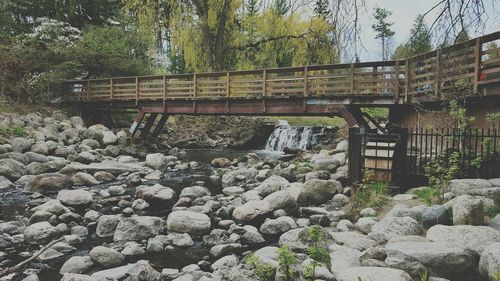 Footbridge over river against sky