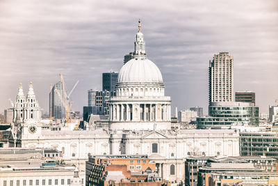 Buildings in city against cloudy sky