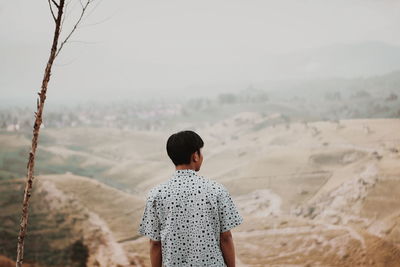 Rear view of man looking at landscape