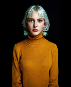 Portrait of a serious young woman over black background