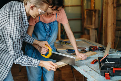 Man and woman working in workshop, doing furniture, reuse old materials to new product. awareness in