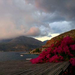 Scenic view of sea and mountains against cloudy sky