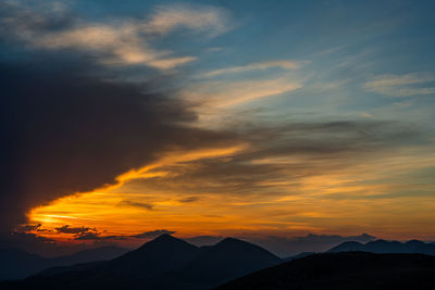Scenic view of silhouette mountains against sky during sunset