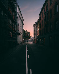 Surface level of road amidst buildings against sky