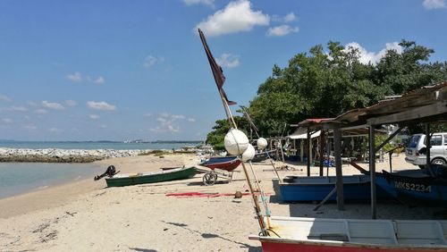 Boats moored on beach against sky