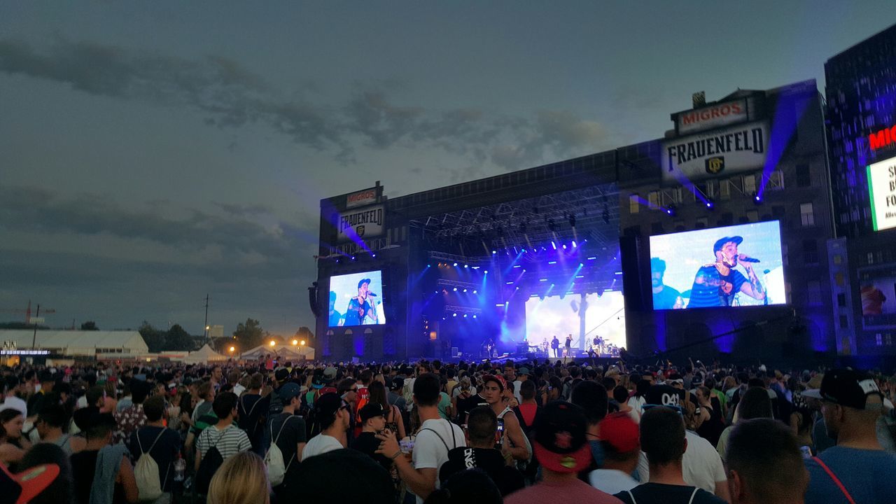 large group of people, crowd, illuminated, lifestyles, men, person, night, leisure activity, celebration, sky, enjoyment, arts culture and entertainment, spectator, event, music, music festival, lighting equipment, built structure
