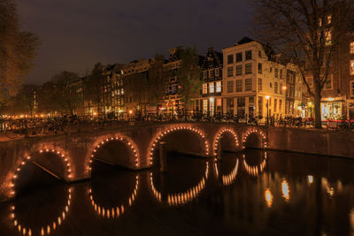 Reflection of illuminated buildings in river at night