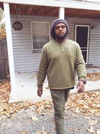 Portrait of mature man standing outside house