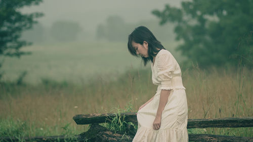 Side view of woman standing on field