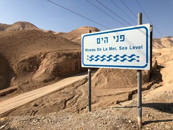 Information sign on desert against blue sky