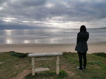 Rear view of woman standing on beach