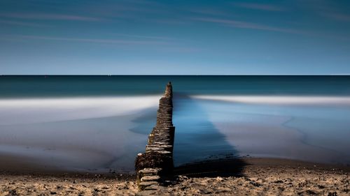 Cross on beach against the sky