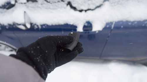 Close-up of person wearing shoes on snow