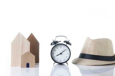 Close-up of clock on table against white background