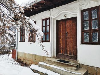 House and tree by building during winter