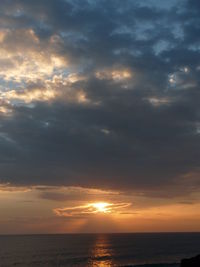 Scenic view of sea against dramatic sky during sunset