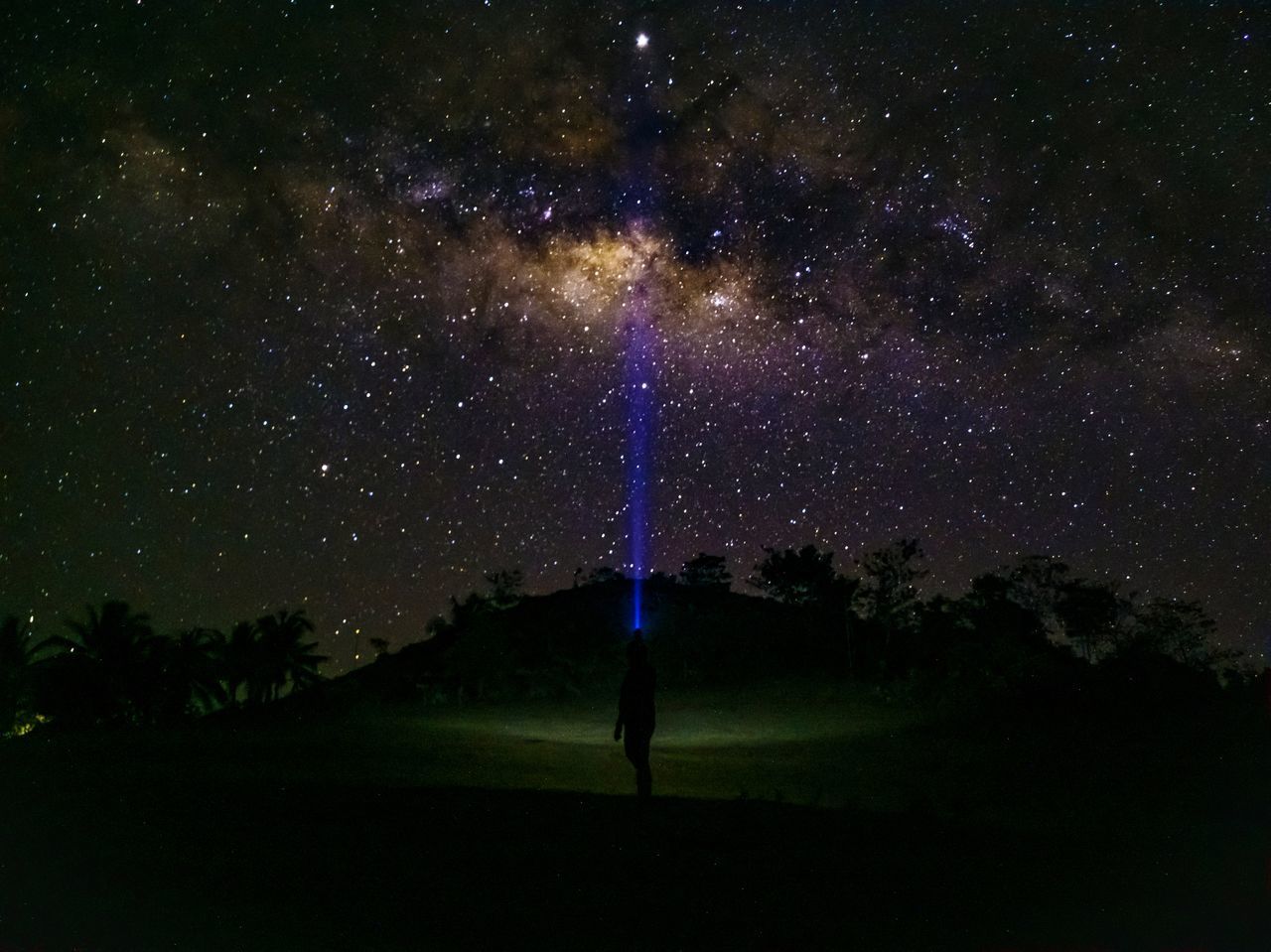 MAN STANDING ON FIELD AGAINST SKY AT NIGHT