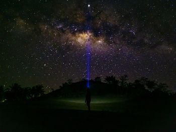 Full length of woman standing on field against sky at night