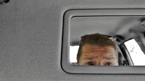 Close-up of man looking through car window