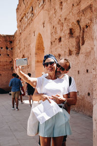 Rear view of a couple taking themself a selfie on street