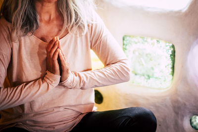 Midsection of woman sitting at home