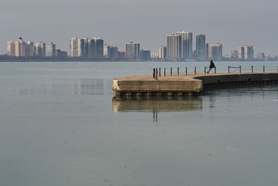 Scenic view of sea by buildings against sky