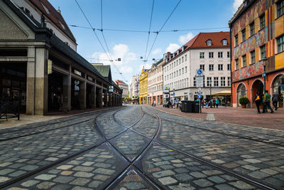 Railroad track in city against sky