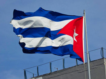 Low angle view of flag against blue sky