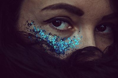 Close-up of woman with glitter on her face