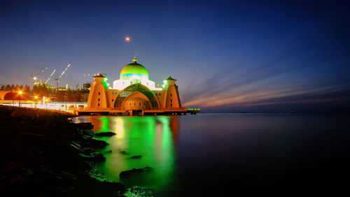 Illuminated building against sky at night