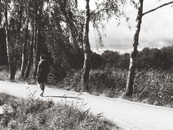 Rear view of man walking on road in winter