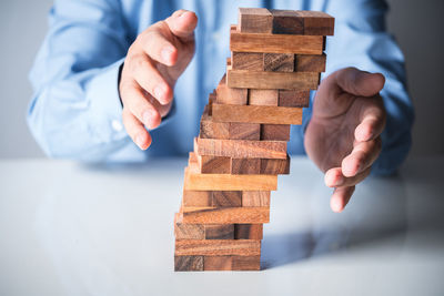 Man playing with stuffed toy on wooden table