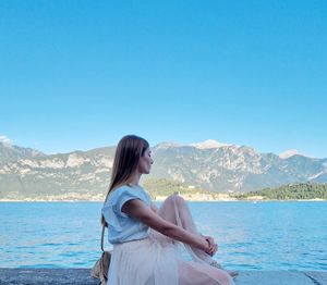 Full length of senior woman against mountains against clear blue sky