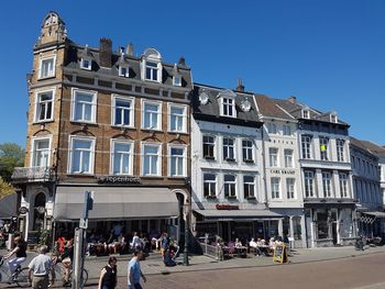 People on street against buildings in city