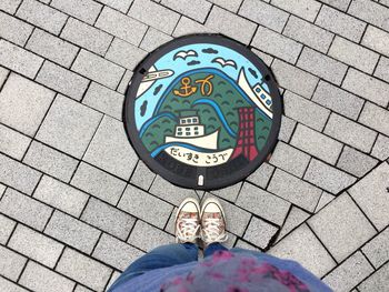 Low section of person standing on footpath