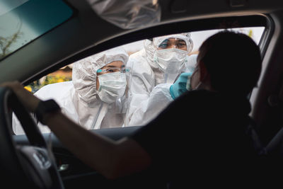 Midsection of man traveling in car