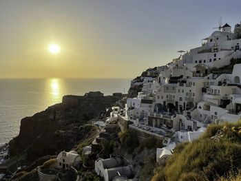 High angle view of townscape by sea against sky during sunset