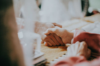 Midsection of couple holding hands