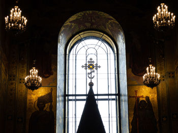 Illuminated lamp hanging on ceiling of building