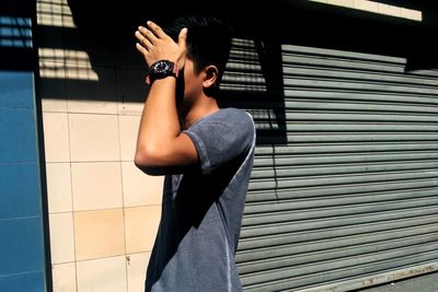 Portrait of woman standing against wall