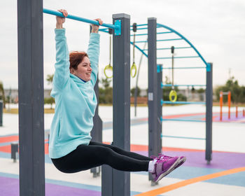 Full length of woman exercising at playground