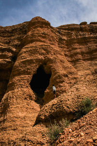 Rear view of man on rock against sky