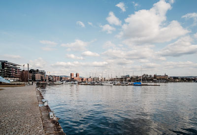 Scenic view of river by buildings against sky